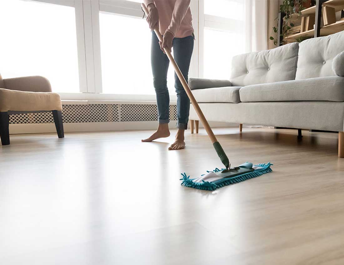 Lady sweeping floor | Carpet House Flooring Center