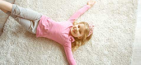 Cute baby girl laying on rug | Carpet House Flooring Center