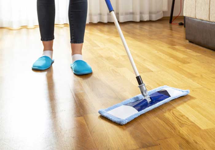 Lady sweeping vinyl flooring | Carpet House Flooring Center